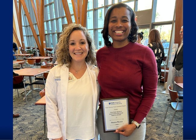 Duke CRNA alumna Shanna Weaver poses next to Dr. Emily Funk. Weaver is holding an award.
